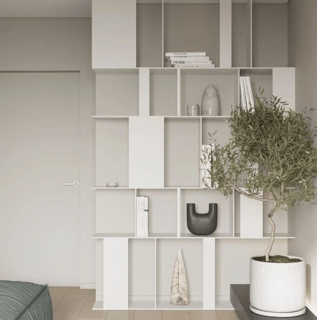 Floor-to-ceiling white bedroom shelves with a plant in front.